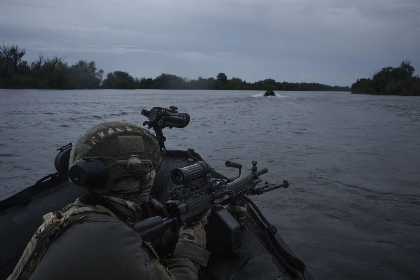 Українські військові пливуть на човні річкою Дніпро на передовій поблизу Херсона, Україна, неділя, 11 червня 2023 року